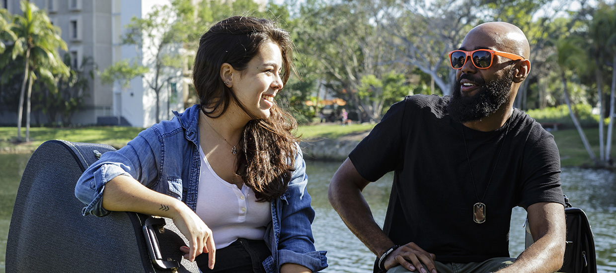 Two students relaxing during a break by Lake Osceola at the University of Miami Coral Gables campus